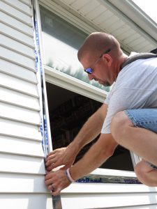 A technician installing new windows on a home