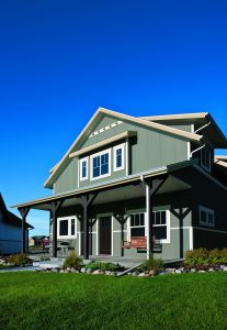 A large, two-story home featuring a variety of windows, including single-hung