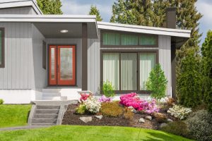 exterior view of a house with wood and glass door and large windows