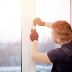 A master technician installing a new window at a home