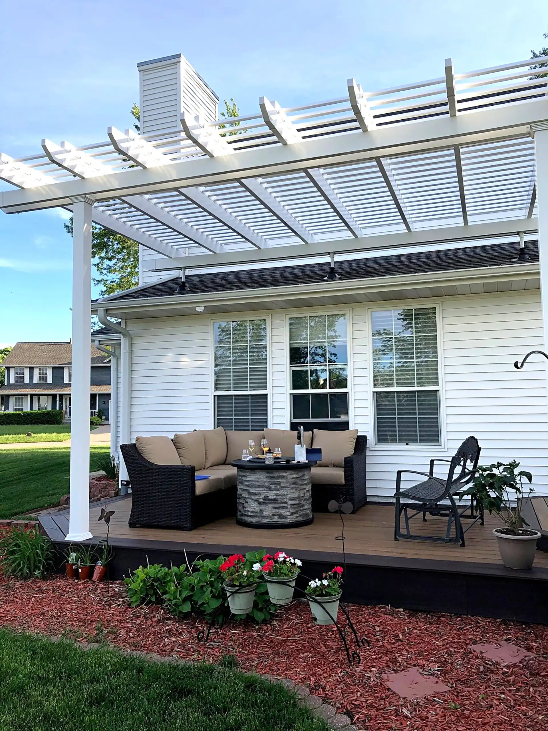 Pergola Design Ideas - Photo of a white pergola with slatted roof on a raised deck with an outdoor living room - Pergola Builders in Michigan